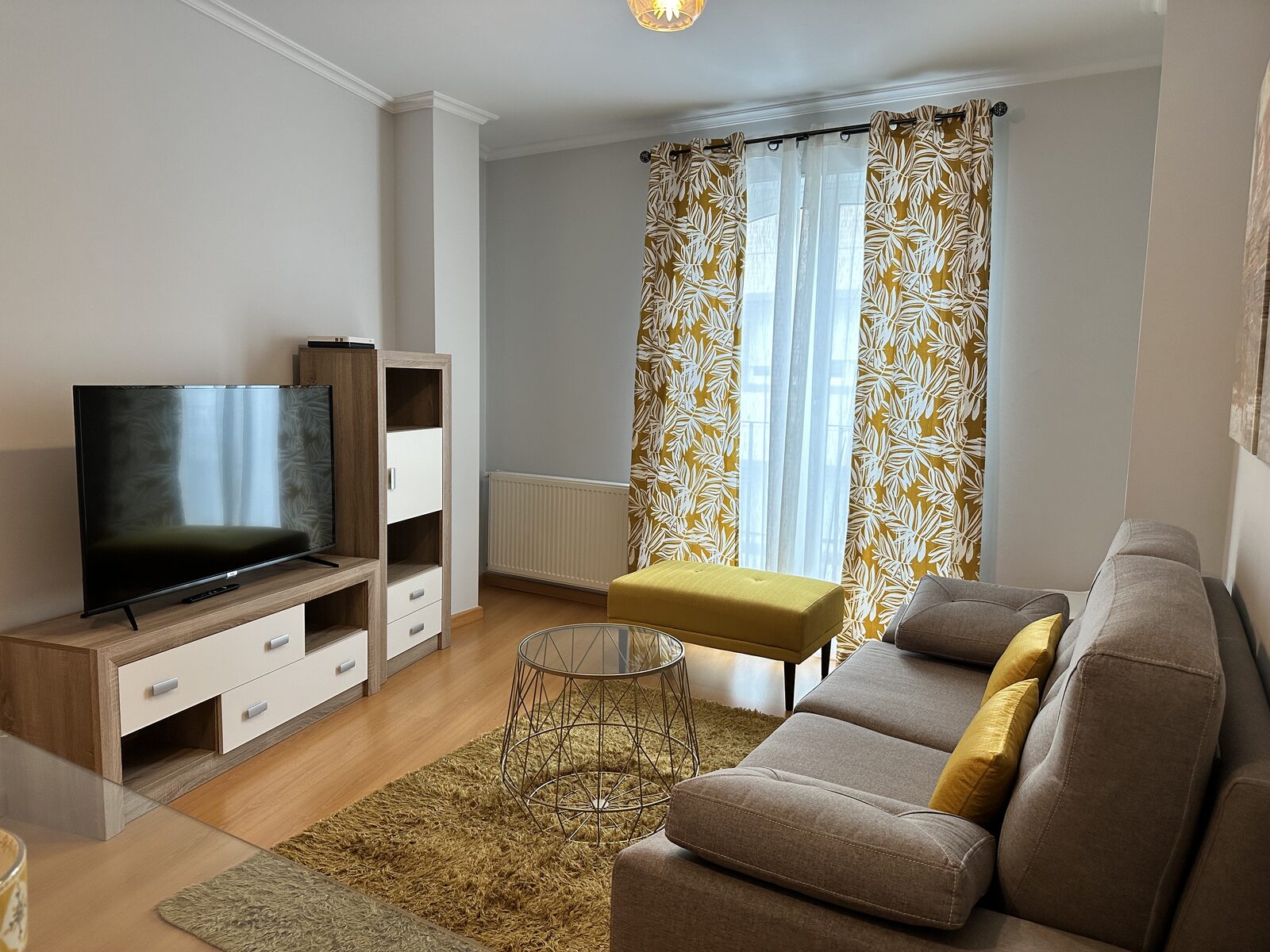 Salón con sofá, TV y amplio ventanal